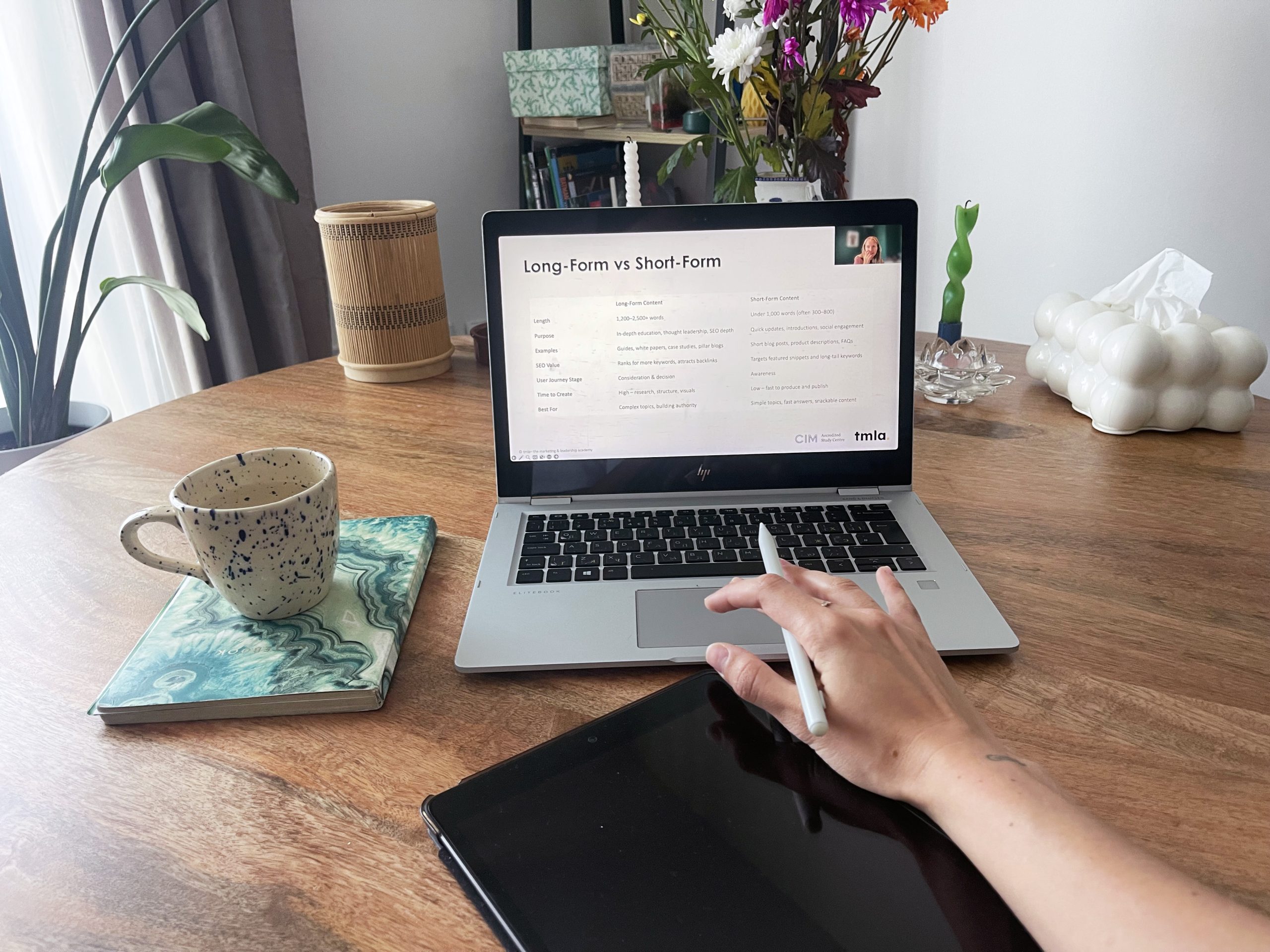 A picture from TMLA student, Liza, of her study set up. It shows her desk with her laptop displaying the TMLA student learning content, with her ipad in front of her for taking notes. She also has a cup of tea beside her laptop.