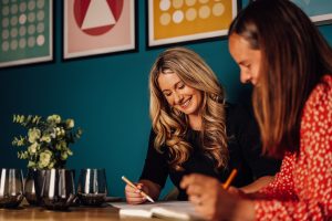Anna, Director of TMLA, sat with colleague at desk looking at notes together